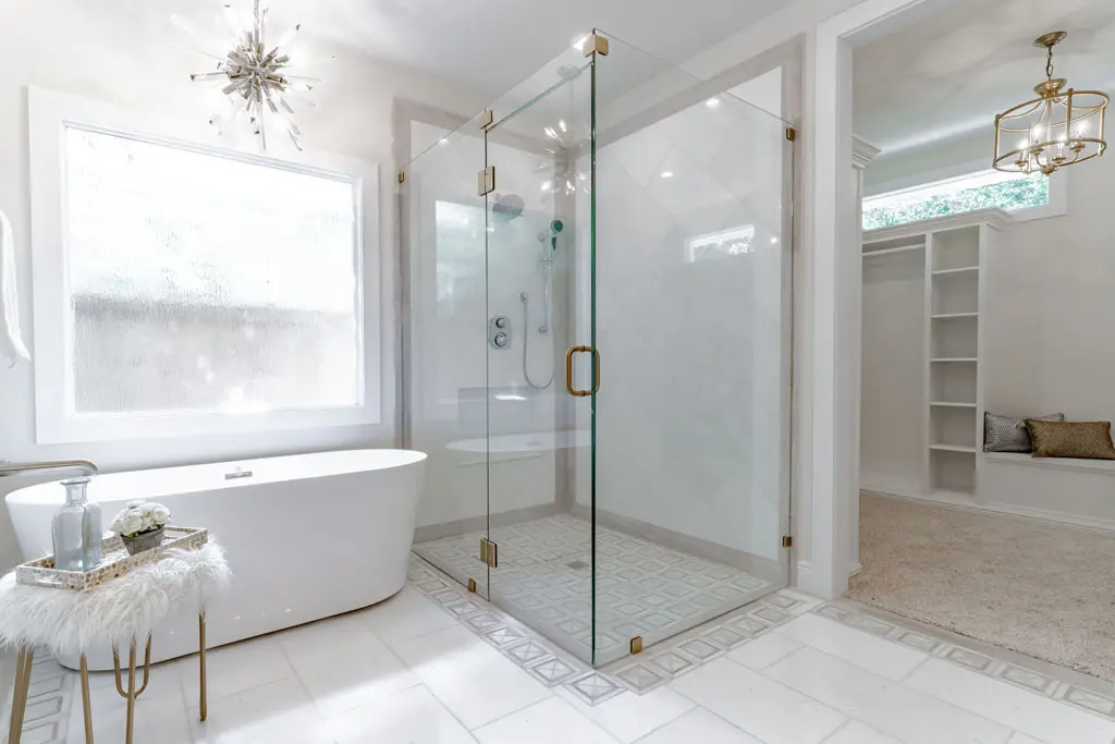 Modern spa-style bathroom with soaking tub and walk-in shower featuring brass hardware in San Antonio