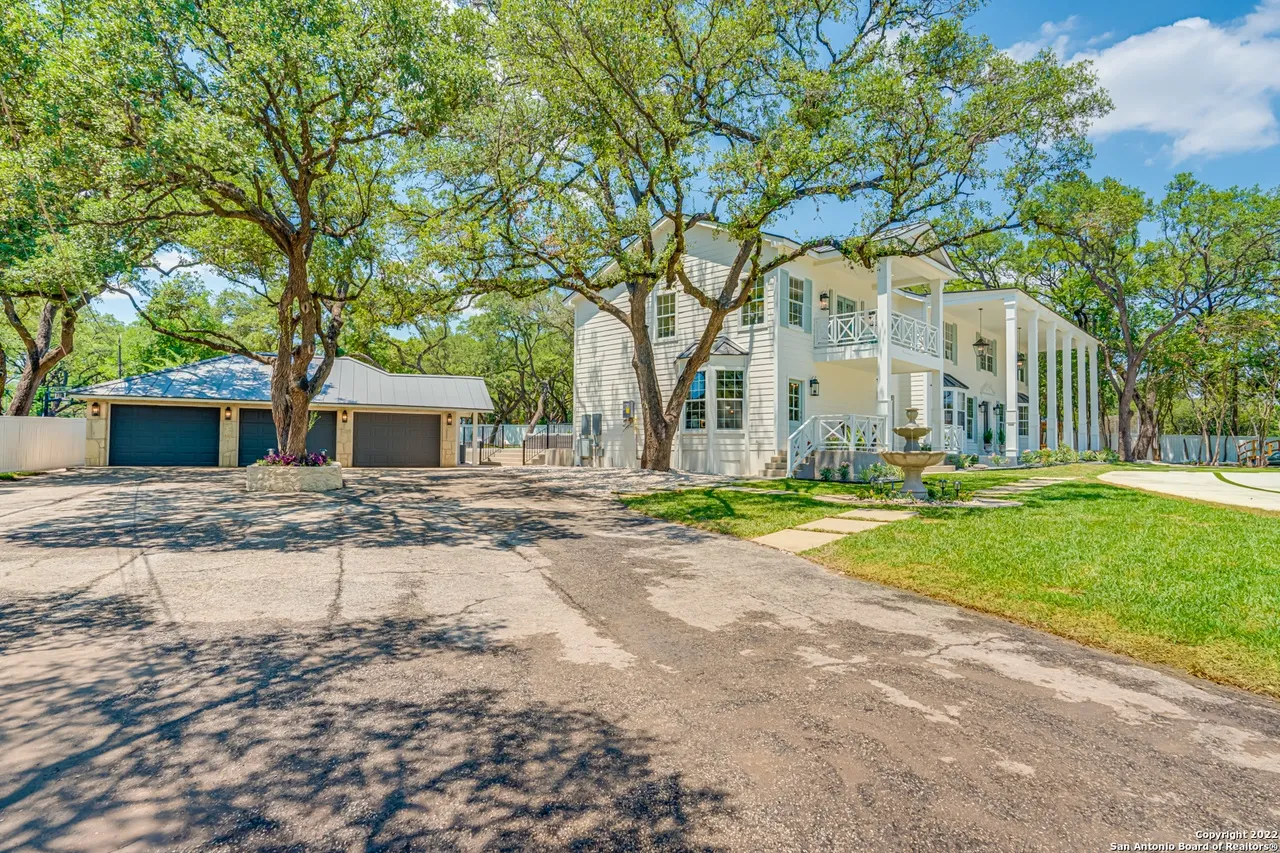 Castle Hills Manor exterior remodel showing front motor court, three-car garage, stone fountain, and Southern Colonial wraparound porch in San Antonio TX