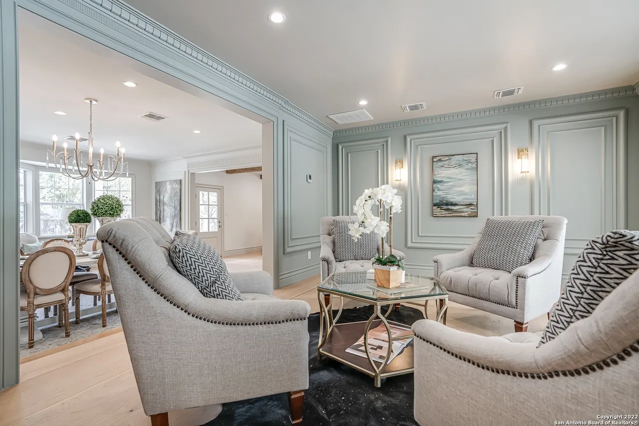 Formal sitting room remodel with decorative wall panel molding, sage-painted walls, and view to dining room in Castle Hills San Antonio TX