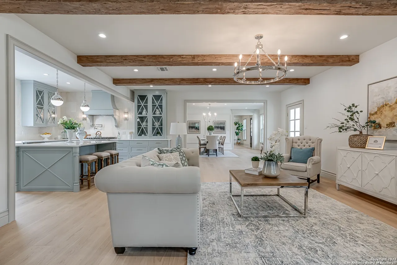 Great room remodel open to sage green kitchen with custom cabinetry and reclaimed wood beam ceiling in Castle Hills San Antonio TX