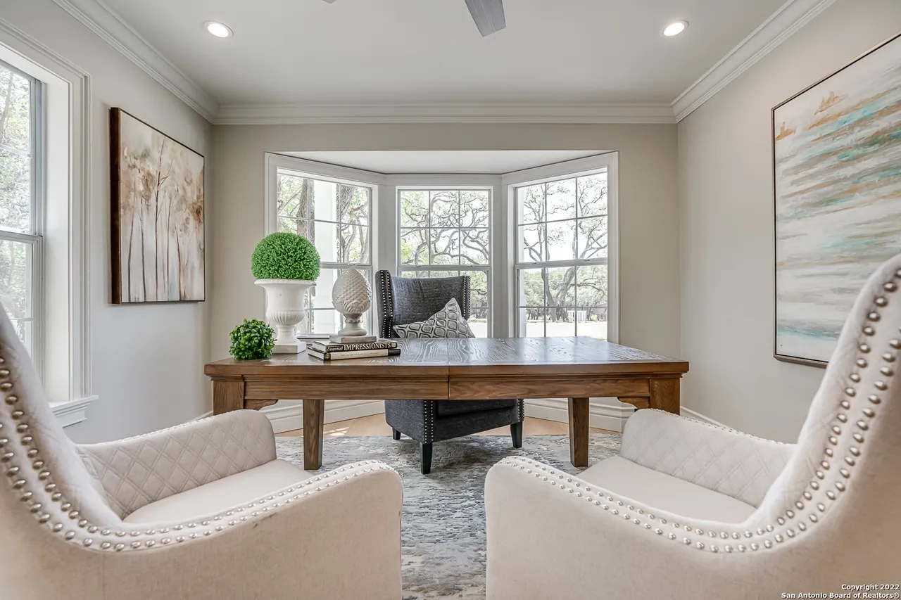 Castle Hills home office remodel with bay window, wood executive desk, and upholstered armchairs in San Antonio TX