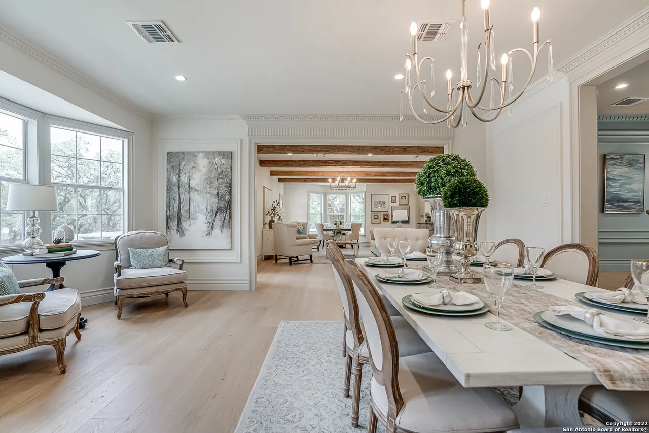 Remodeled dining room with European white oak flooring, decorative crown molding, and chandelier in Castle Hills San Antonio TX