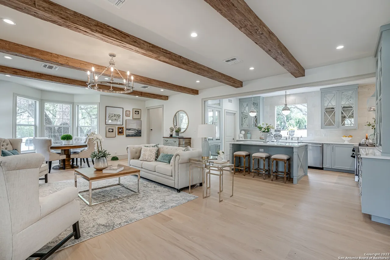 Open plan living, dining, and kitchen remodel with reclaimed wood beams and European white oak floors in Castle Hills San Antonio TX