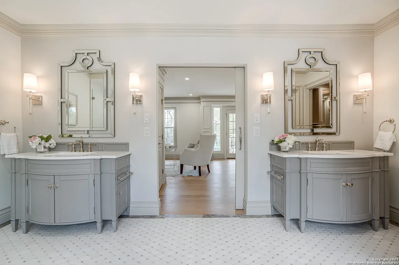 Primary bathroom remodel with dual curved gray vanities, ornate venetian mirrors, and wall sconces in Castle Hills San Antonio TX