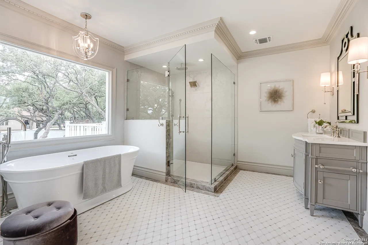 Primary spa bath remodel with freestanding soaking tub, frameless glass shower, and marble tile floor in Castle Hills San Antonio TX