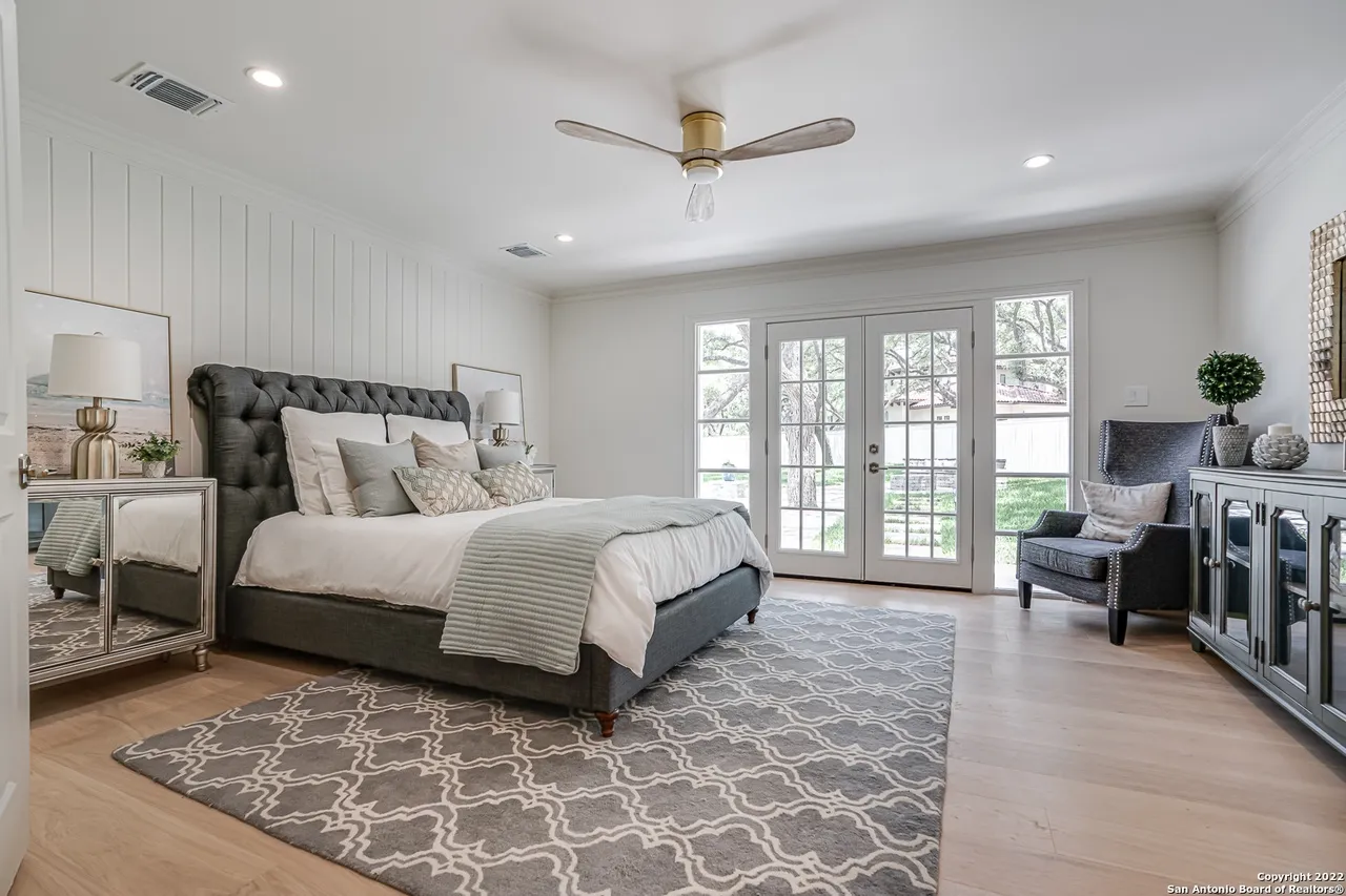 Secondary primary bedroom remodel with shiplap accent wall, tufted headboard, and French doors to backyard in Castle Hills San Antonio TX