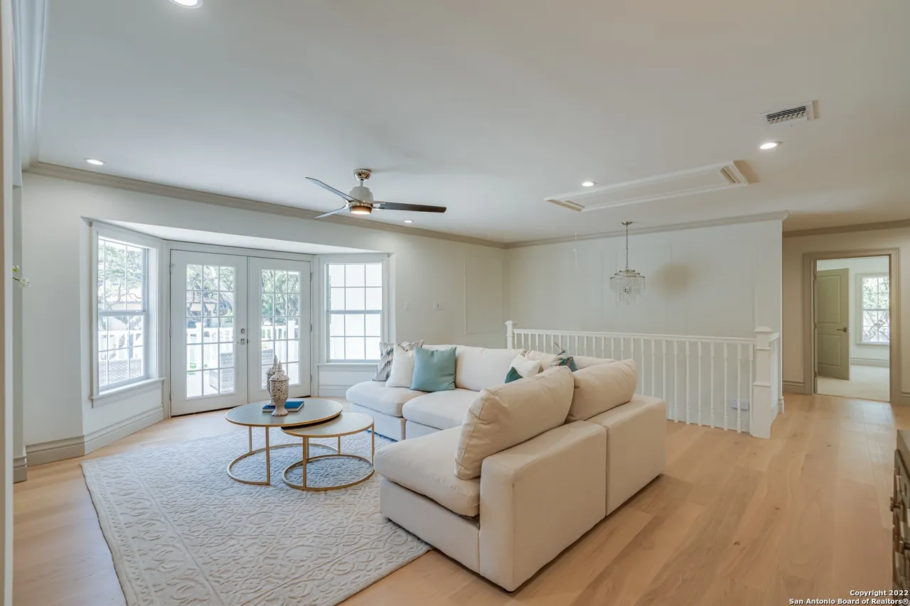 Upstairs living room remodel with sectional sofa, French doors to balcony, and European white oak floors in Castle Hills San Antonio TX