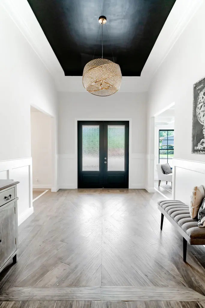 Modern entryway renovation with statement lighting and herringbone flooring in San Antonio