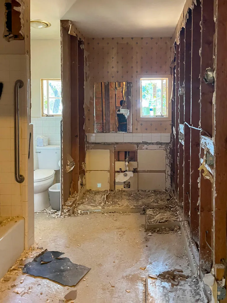 Master bathroom before renovation showing outdated fixtures and wallpaper during demolition in San Antonio TX