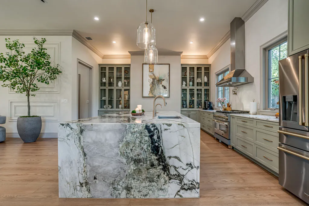Stunning open-concept kitchen remodel with waterfall marble island, sage green cabinetry, and pendant lighting in San Antonio TX